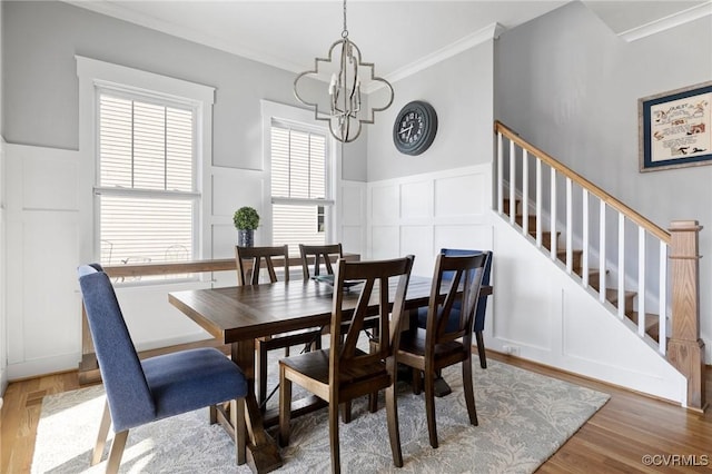 dining space featuring dark hardwood / wood-style flooring, ornamental molding, and an inviting chandelier