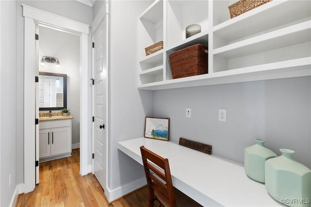 office space with light wood-type flooring and built in desk