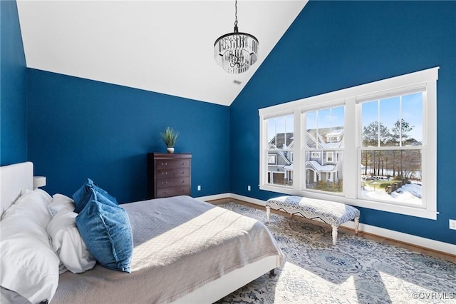 bedroom with high vaulted ceiling and a notable chandelier