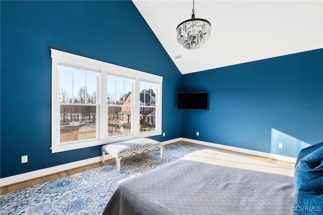 bedroom with high vaulted ceiling, an inviting chandelier, and hardwood / wood-style floors