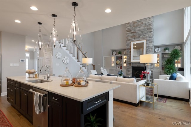 11163 Independence Rd, Ashland, VA 23005 - kitchen featuring sink, a stone fireplace, built in features, stainless steel dishwasher, and an island with sink