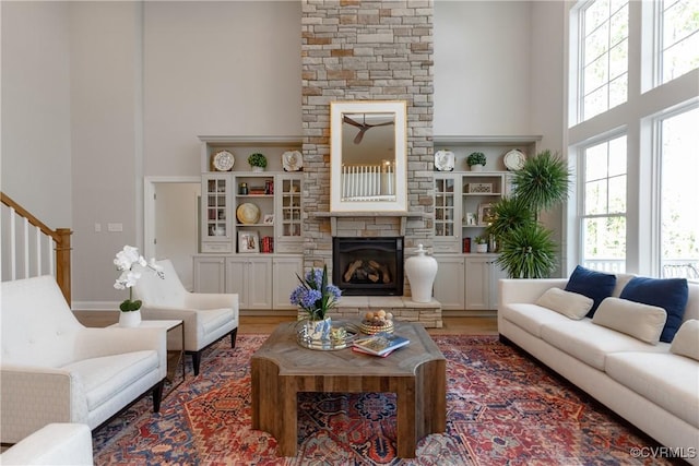 11163 Independence Rd, Ashland, VA 23005 - living room with hardwood / wood-style floors, a towering ceiling, a stone fireplace, and built in shelves