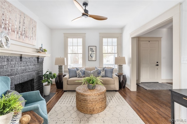 living room with hardwood / wood-style floors, a brick fireplace, and ceiling fan