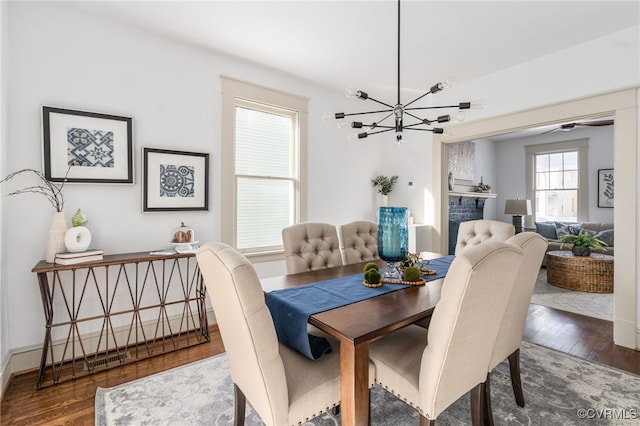 dining space with wood-type flooring, plenty of natural light, and a notable chandelier