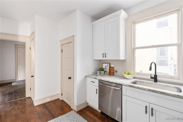 kitchen featuring backsplash, light stone counters, sink, dishwasher, and white cabinetry