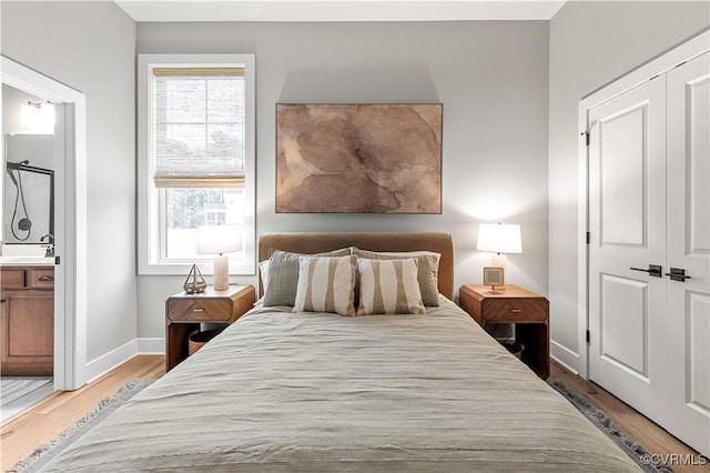 bedroom with wood-type flooring, ensuite bath, and a closet