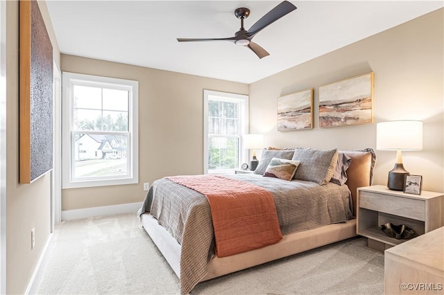 bedroom with multiple windows, light carpet, and ceiling fan