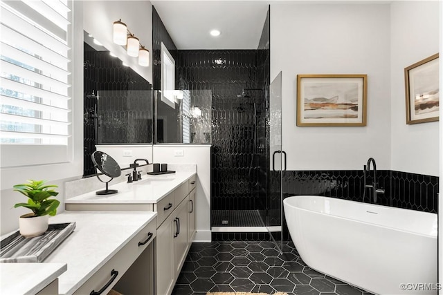 bathroom with vanity, independent shower and bath, and tile walls