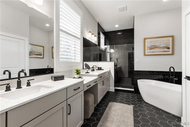 bathroom featuring shower with separate bathtub, vanity, and tile walls