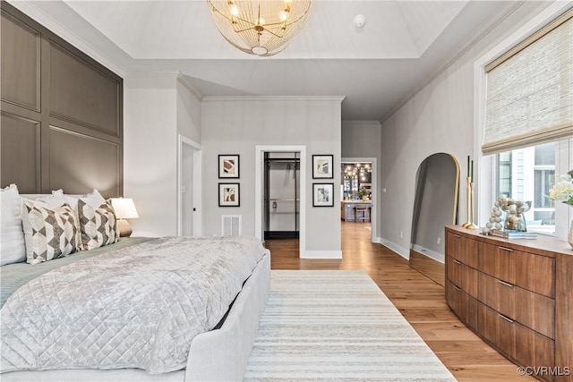 bedroom with a chandelier, light hardwood / wood-style floors, and ornamental molding