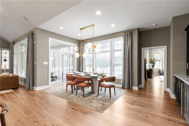 dining space with light hardwood / wood-style flooring and a chandelier