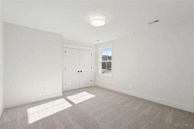 spare room featuring light colored carpet