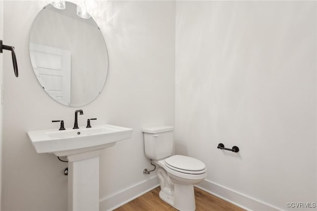 bathroom with toilet and wood-type flooring