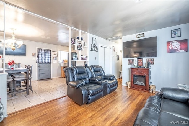 living room featuring light hardwood / wood-style flooring and an inviting chandelier