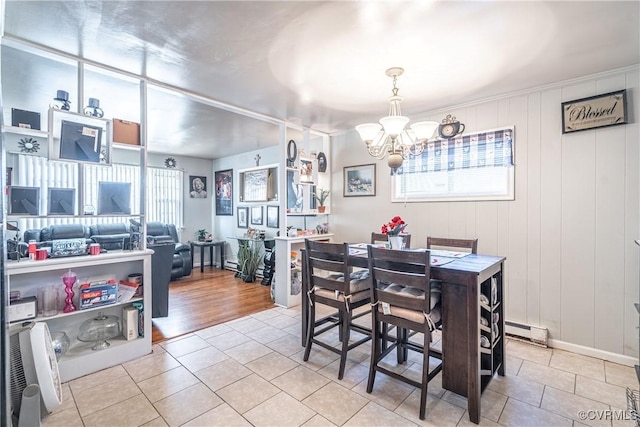 dining room featuring plenty of natural light, light tile patterned floors, baseboard heating, and a chandelier