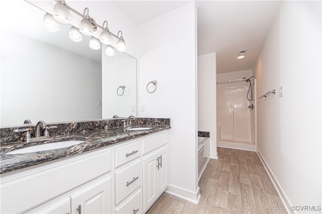 bathroom with hardwood / wood-style flooring, vanity, and independent shower and bath