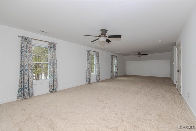 carpeted spare room with ceiling fan, visible vents, and baseboards