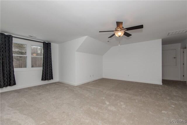 additional living space with carpet, lofted ceiling, visible vents, a ceiling fan, and baseboards