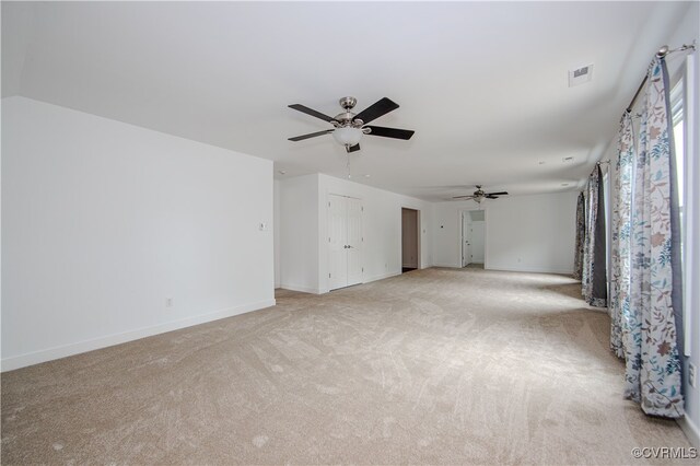 unfurnished living room featuring light colored carpet and ceiling fan