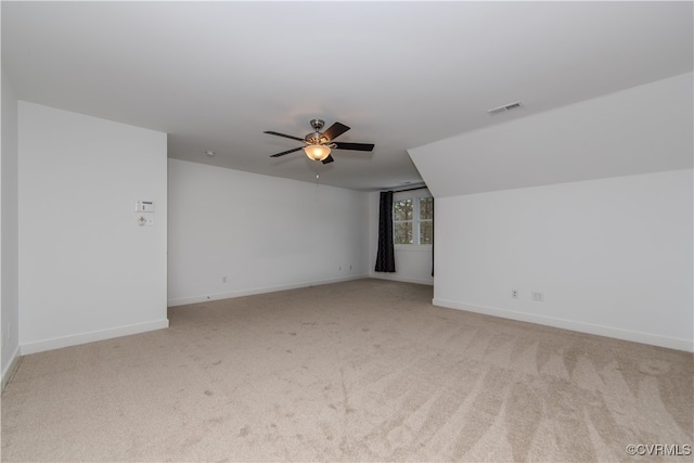 additional living space featuring a ceiling fan, visible vents, light carpet, and baseboards