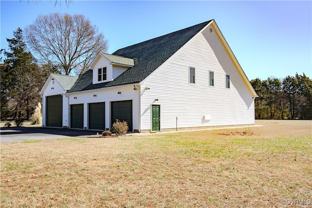 view of home's exterior with a garage and a lawn