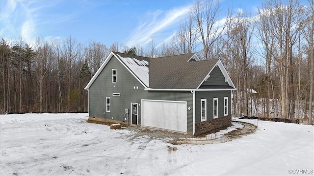 view of snow covered exterior featuring a garage