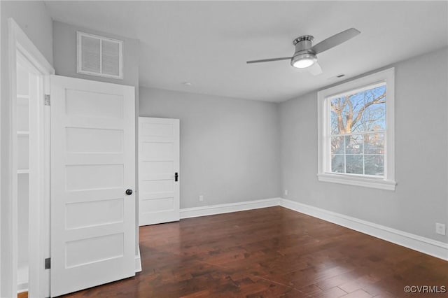 empty room with ceiling fan and dark wood-type flooring