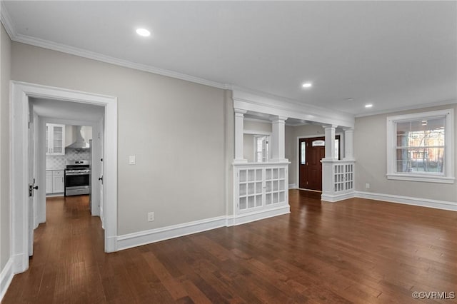 unfurnished living room featuring ornate columns, crown molding, and dark wood-type flooring