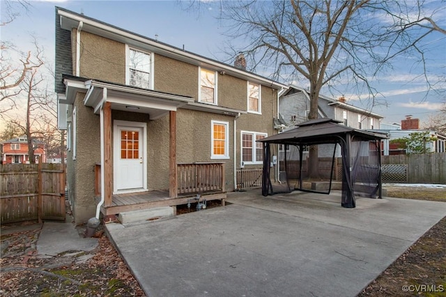 rear view of house with a gazebo and a patio