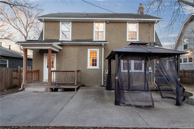 rear view of property featuring a gazebo and a patio