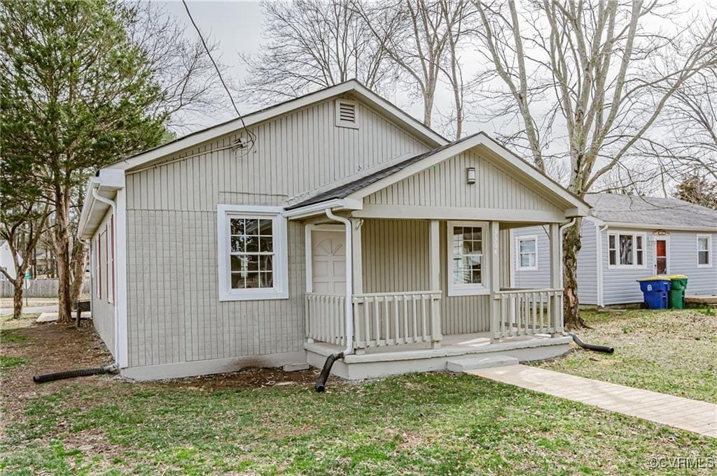 bungalow-style home with a porch and a front lawn