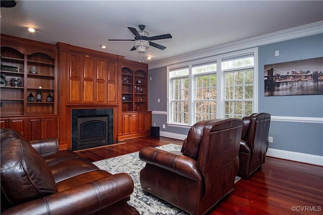 living room featuring dark hardwood / wood-style flooring, ornamental molding, ceiling fan, and built in features