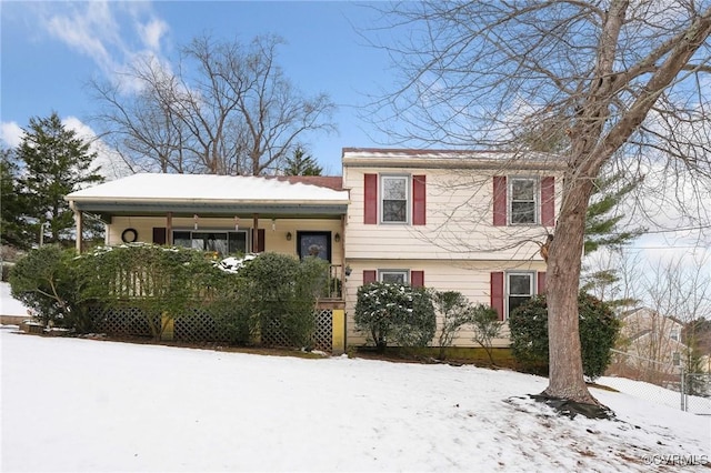 tri-level home with fence and a porch