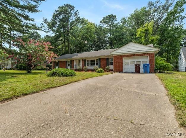 ranch-style home with a garage and a front yard