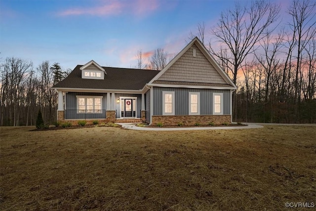 craftsman inspired home featuring a lawn and covered porch