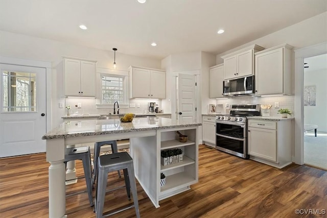 kitchen with white cabinetry, a kitchen island, and appliances with stainless steel finishes