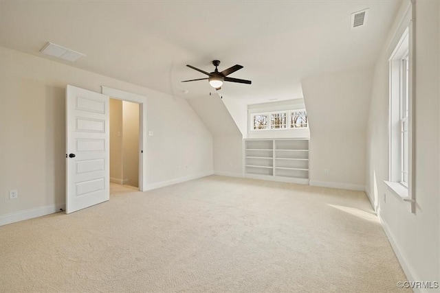 additional living space with ceiling fan, light colored carpet, and vaulted ceiling