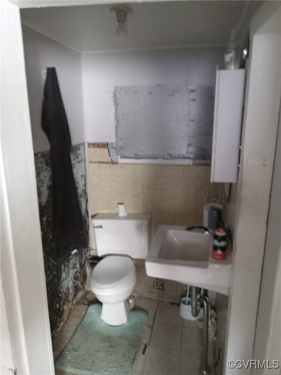 bathroom featuring sink, toilet, and decorative backsplash