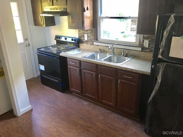 kitchen featuring sink, backsplash, dark wood-type flooring, and black appliances