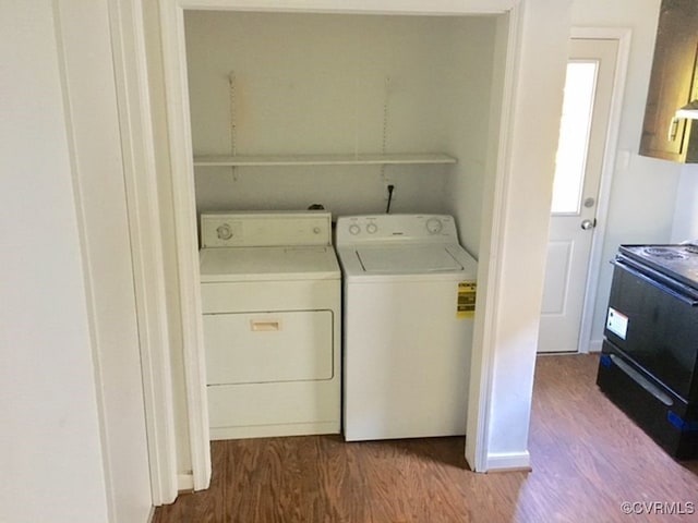 laundry area featuring washing machine and dryer and hardwood / wood-style flooring