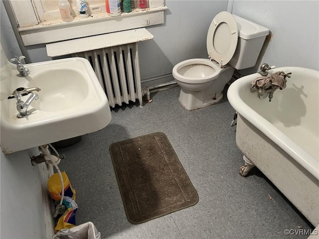 bathroom with radiator heating unit, toilet, a bathing tub, and sink