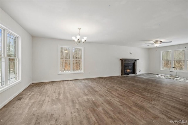 unfurnished living room featuring a fireplace with flush hearth, visible vents, baseboards, and wood finished floors