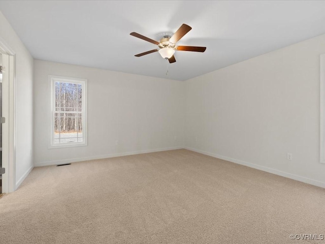 unfurnished room with light carpet, baseboards, visible vents, and a ceiling fan