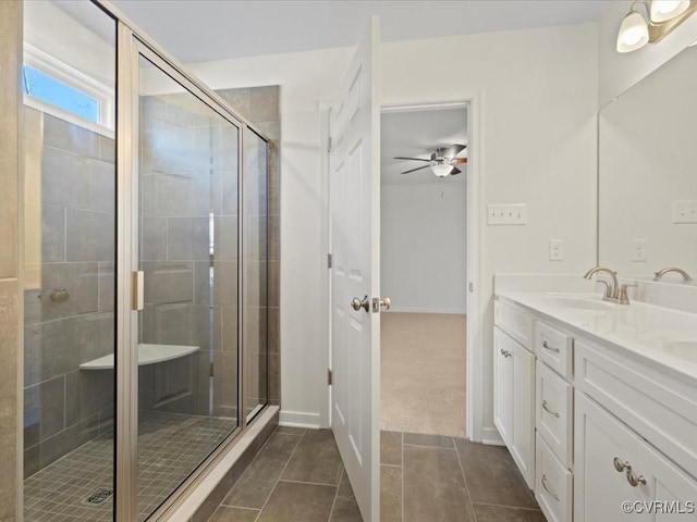 bathroom featuring double vanity, a ceiling fan, tile patterned floors, a shower stall, and a sink