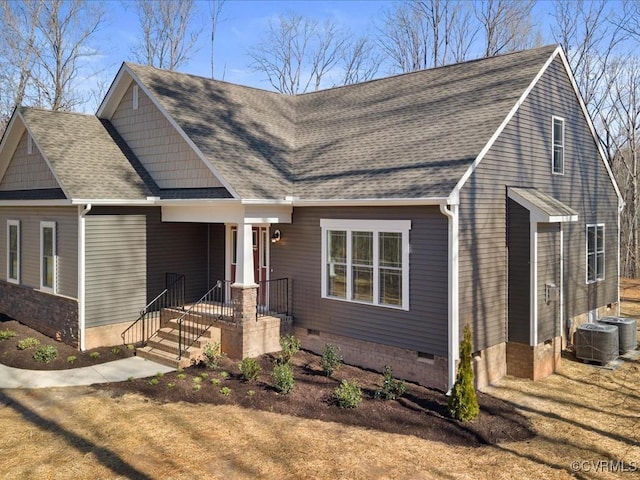 view of front of home with roof with shingles, central AC unit, and crawl space