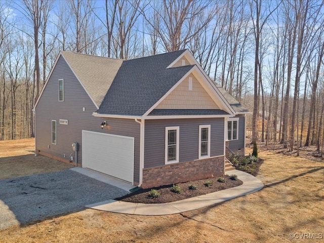 view of property exterior featuring a garage, driveway, roof with shingles, and stone siding