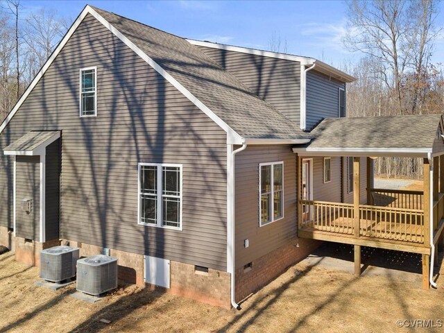 rear view of property featuring crawl space, roof with shingles, a deck, and central AC unit