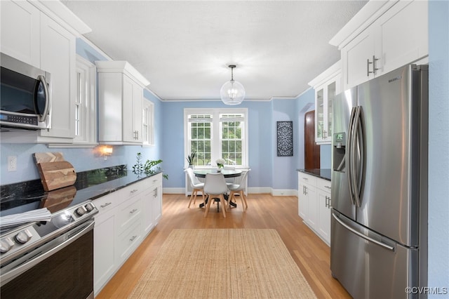 kitchen with white cabinetry, crown molding, light hardwood / wood-style floors, and appliances with stainless steel finishes