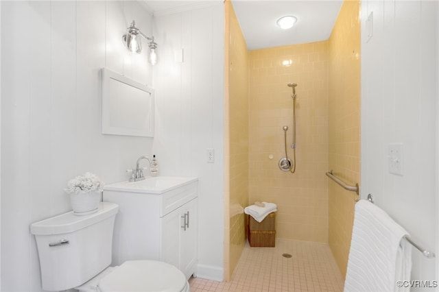 bathroom with toilet, vanity, and tiled shower