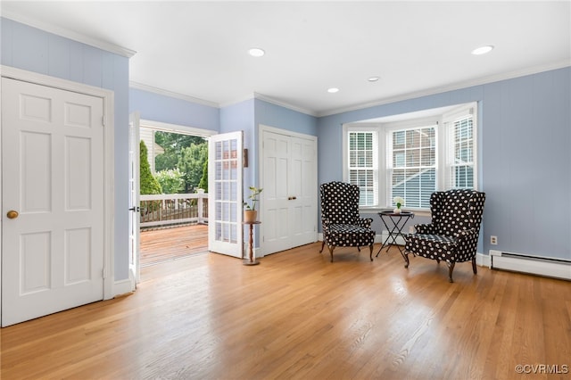 living area with light hardwood / wood-style floors, ornamental molding, and baseboard heating